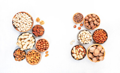Wall Mural - Nuts in bowls. Almonds, hazelnuts, walnuts and other. Healthy food snack mix on white table, top view, copy space