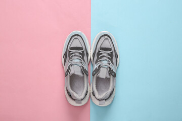 Wall Mural - Sports sneakers on a blue-pink pastel background. Running shoes. Pastel color trend