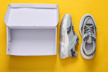 Wall Mural - New sports sneakers with box on yellow  background