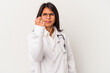 Young doctor latin woman isolated on white background showing fist to camera, aggressive facial expression.