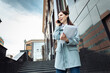 © splitov27 - Modern business woman talking on the phone while holding a folder with documents on the stairs