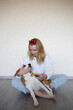 © Aleksandra Iarosh - a young woman combing a beagle dog with a furminator. grooming at home