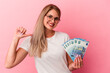 © Asier - Young russian woman holding bills isolated on pink background feels proud and self confident, example to follow.