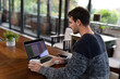 © Wavebreak Media - Caucasian man sitting at table in kitchen working remotely using laptop