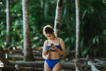 Woman In Bikini With Coconut On Beach