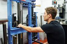Male Mechanic Using Hydraulic Press