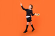 © deagreez - Full length body size view of pretty cheerful dreamy preteen girl jumping drawing isolated over bright orange color background
