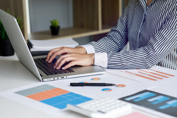 Business female working on calculator laptop computer Financial graphs of the company's performance to create profits and growth,Market research reports income statistics and accounting concept.