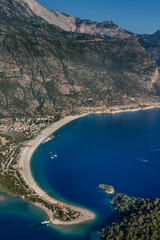 Wall Mural - Amazing aerial view of Blue Lagoon in beach resort in the Fethiye district - Oludeniz.  Turkey. Summer landscape with mountains, green forest, turquoise coast in bright sunny day. Travel background.