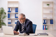 © Elnur - Old male employee working in the office