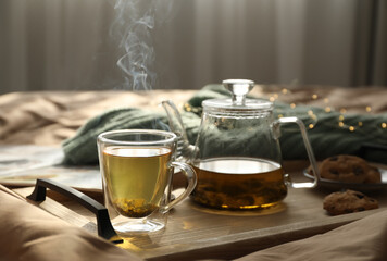 Poster - Wooden tray with freshly brewed tea and cookies on bed in room. Cozy home atmosphere