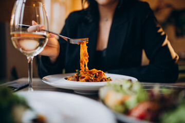 Young woman eating pasta in a cafe