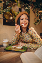 Young woman eating delicious tiramisu in a cafe