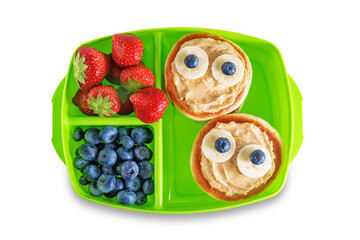 Kid's healthy breakfasts with funny faces in a container on a white isolated background