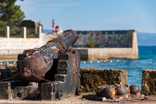 Selective Focus Of Rusty Old Cannon On Shore Of Sea In Split, Croatia.