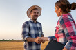 © Budimir Jevtic - Two farmers shaking hands in field during harvest