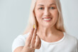 © Pixel-Shot - Mature woman with fish oil on light background
