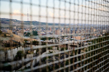 Wall Mural - Beautiful view of the cityscape through the chainlink fence