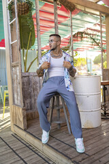 Wall Mural - Vertical shot of a white Caucasian guy posing for a photoshoot in a cafe