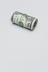 Wall Mural - Roll of dollar paper bills isolated on a white background with free space for text