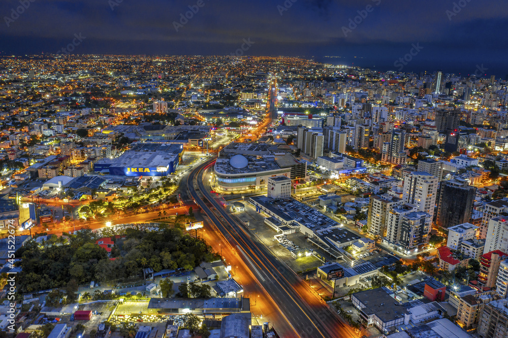Cityscape of Santo Domingo surrounded by lights at night in the Dominican Republic - obrazy, fototapety, plakaty 