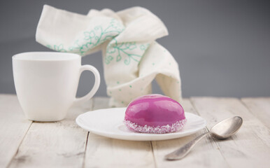 Wall Mural - a cup and heart-shaped cake on a white wooden background