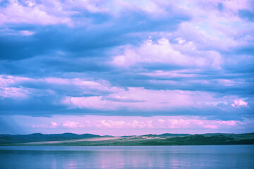 Wall Mural - gentle sunset. purple pink clouds over the turquoise surface of the lake. beautiful landscape backgr