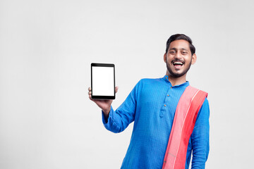 Wall Mural - Young indian farmer showing tablet and giving expression on white background.