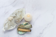 Clear Quartz Minerals, Candle, Palo Santo, White Sage Bundle On Abalone Sea Shell. Incense For Fumigation. Cleansing, Good Energy. Wiccan Witchcraft. Esoteric Spiritual Practice Concept. Flat Lay