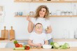 © Serhii - mother with children preparing vegetable salad at home