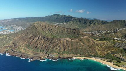 Wall Mural - Aerial daytime drone footage above Koko Head volcano in Oahu, Hawaii. Cobalt blue water waves and a beach at the foot of the volcano.