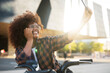 © Jelena - Young lady on electric bicycle on the street. Beautiful african girl taking selfie photo..