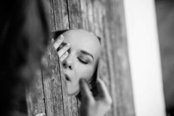 Sticker - Grayscale shot of a European middle-aged lady from Germany holding broken mirror with closed eyes