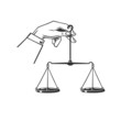 © dobrograph - Hand holds scales of justice.