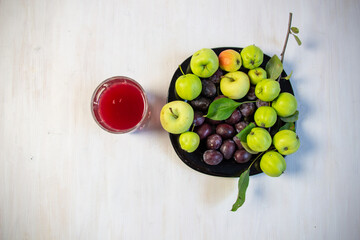 Wall Mural - Compot made of plum and apple in glass on white wooden table