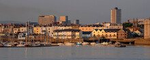 Plymouth, Devon, England, UK. 2021. Waterfront Homes On The River Tamar, Plymouth. Evening Light,  Background The Highrise Buildings In The City Centre.