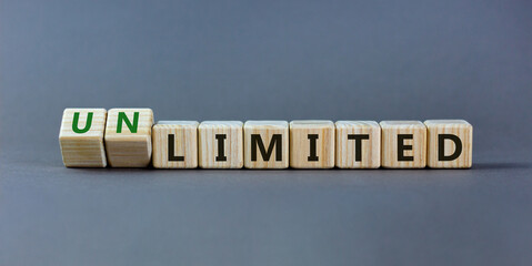 Limited or unlimited symbol. Turned wooden cubes and changed words 'limited' to 'unlimited'. Grey background, copy space. Business, limited or unlimited concept.