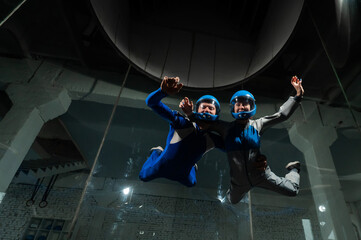 A man and a woman enjoy flying together in a wind tunnel. Free fall simulator