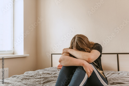Depressed woman crying on bed at home feeling lonely tired and suffering depression. Mental health, stress, problems, loneliness concept.