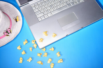 Photo of a laptop mac shot from with hat and popcorn above isola