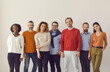 © Studio Romantic - Team of happy confident diverse people standing together on white studio background. Group portrait of mixed race male and female models of different ages posing in comfortable smart casual wear