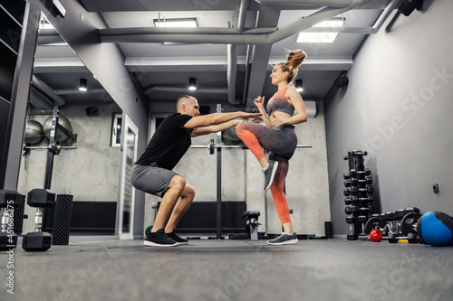 Motivation and support in training, sports lifestyle. The couple does sports exercises together and warms up their muscles. Body mobility and strength in cross fit functional training