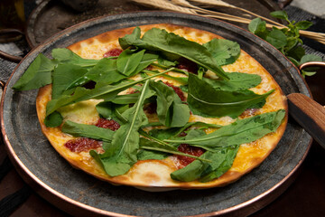 Brazilian pizza with sun-dried tomatoes, arugula and mozzarella