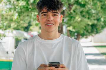 Poster - portrait of teenage boy with mobile phone outdoors