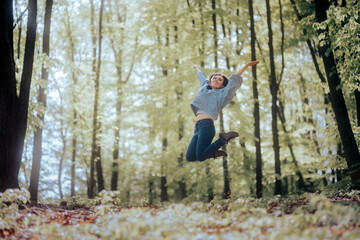 Cheerful Woman full of Joy Jumping in a Forest