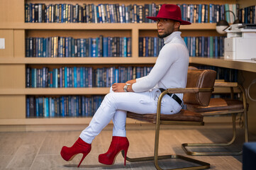 Gay black male fashion model sitting in an office