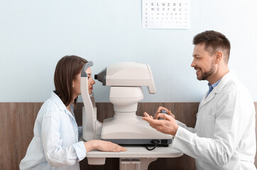 Wall Mural - Ophthalmologist examining young woman in clinic