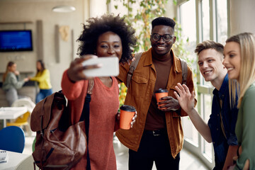 Wall Mural - Happy multi-ethnic college students take selfie on coffee break at cafeteria.