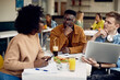 © Drazen - African American student and his friends study on lunch break in cafeteria.