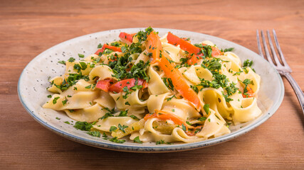 Portion of vegetarian pasta with bell pepper sauce on a plate, close-up